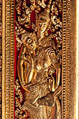 Wat Xieng Thong temple in Luang Prabang, Laos. Detail of the gilded wood carvings of the doors of the Royal Funerary carriage hall. 